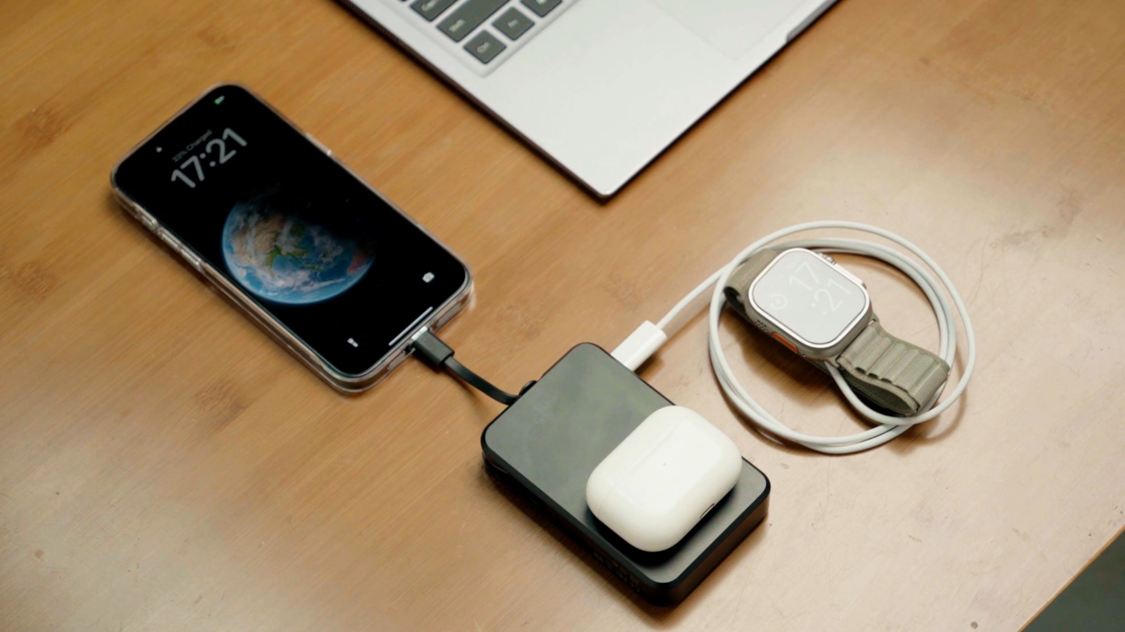 商務人士在會議室使用 65W-100W PD 快充行動電源，同時為筆電與手機充電。